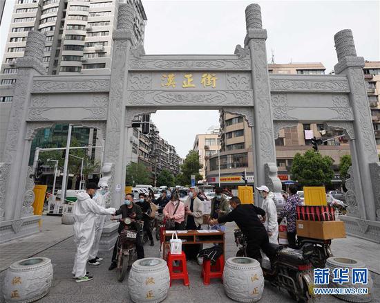  4月16日，進(jìn)出武漢漢正街步行街的人員在掃描健康碼。新華社記者 王毓國 攝